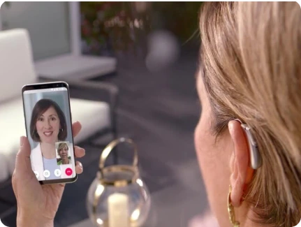 Mulher com aparelho auditivo infinio no ouvido